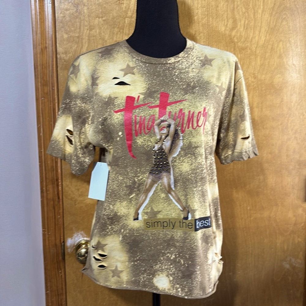 Women’s distressed graphic tee. Rhinestone accents. Raw hemline.